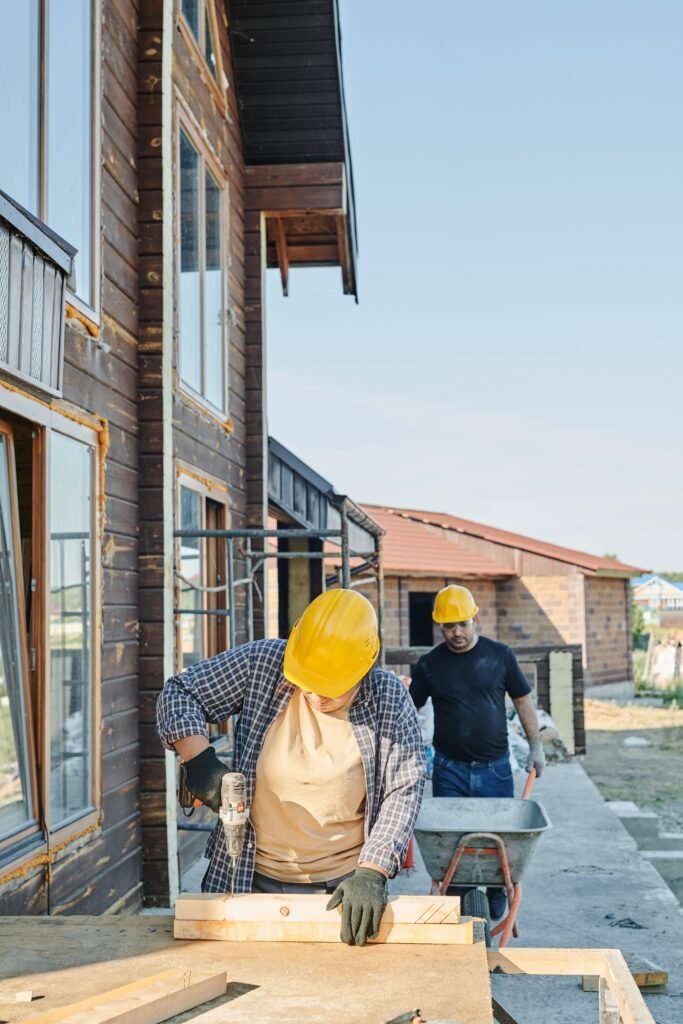 Two men installing wooden flooring in a house, showcasing their craftsmanship and attention to detail.