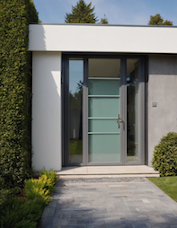 A renovated modern home featuring a glass door and a stone walkway, blending contemporary design with natural elements.